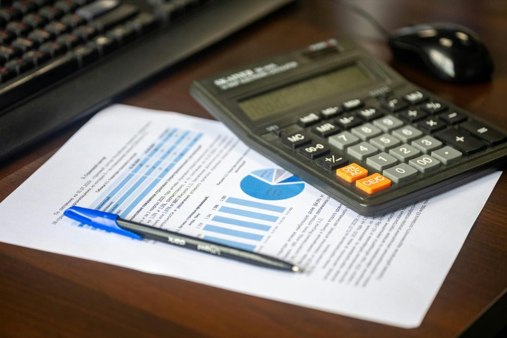 Calculator and compliance documents representing the hidden costs of non-compliance for regulated SMBs