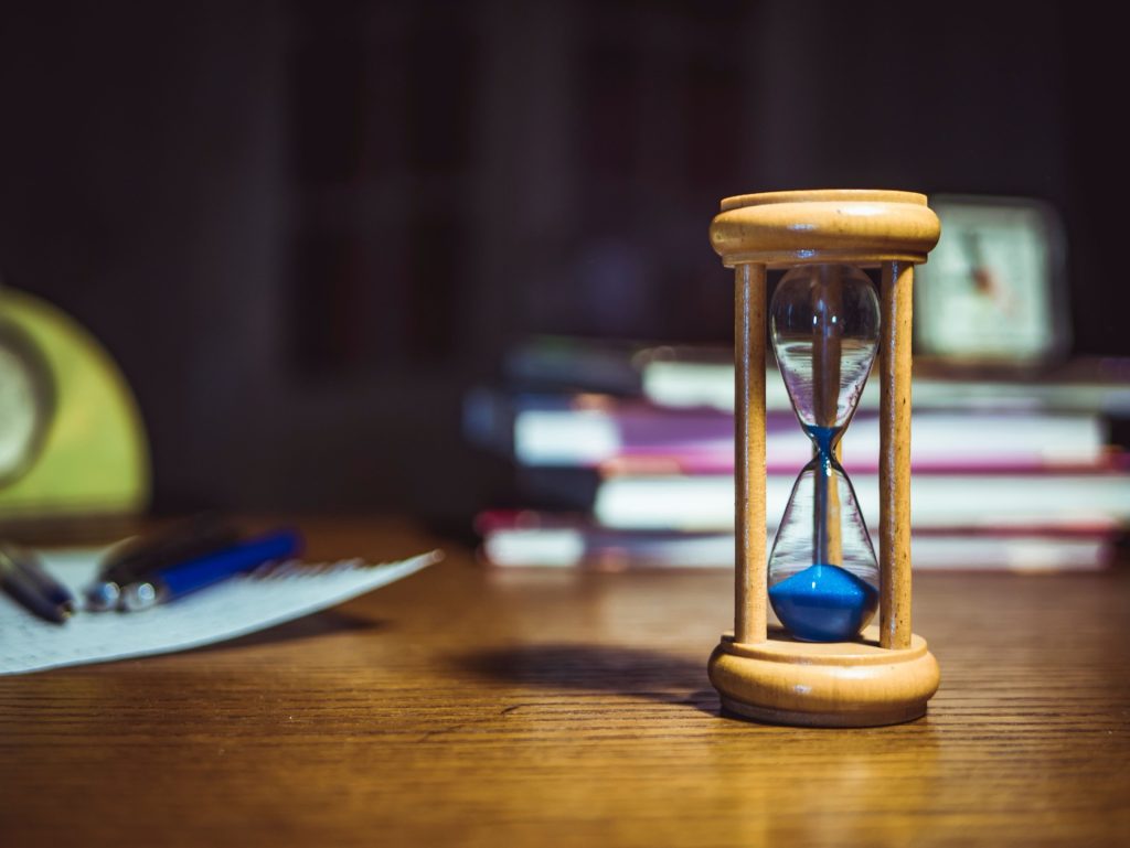 Why an ATO takes so long: hourglass and compliance binders illustrating slow Authority to Operate timelines