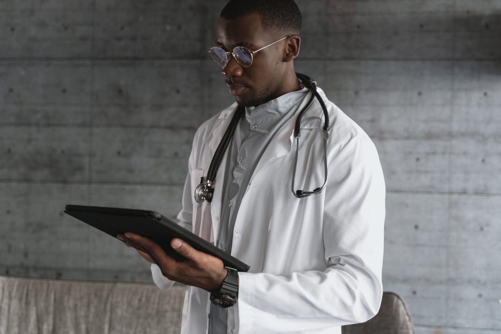 Healthcare professional reviewing patient data on a tablet in a modern clinic environment